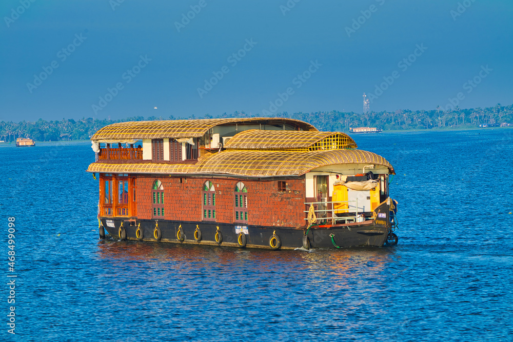 A double-decker houseboat sailing in the lake. Boathouse in Kerala (known as Kettuvallam), southwestern India. Jan. 2018