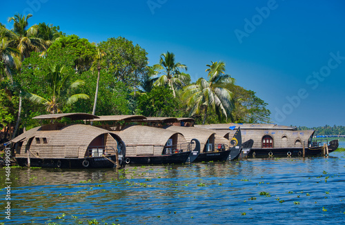 Several boathouses are docked on the shore. Boathouse in Kerala backwaters (known as Kettuvallam), southwestern India. 2018 photo