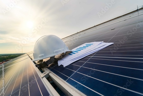 White safety helmet and check chart on the solar cell board.Natural energy.Solar panel Photovoltaic installation,alternative electricity source - Sustainable Resources image Concept photo