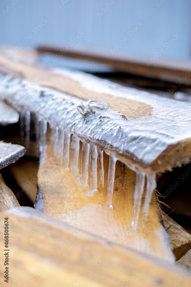 Icicles hang on wooden planks. The first frost in the village. Icicles hang on wooden planks. The first frost in the village.