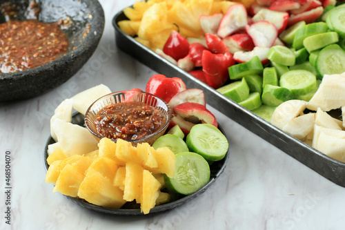 Rujak Buah, Sliced Indonesian Fruit Salad, Served with Spicy Brown Sugar sauce and Ground Peanuts. White Background photo