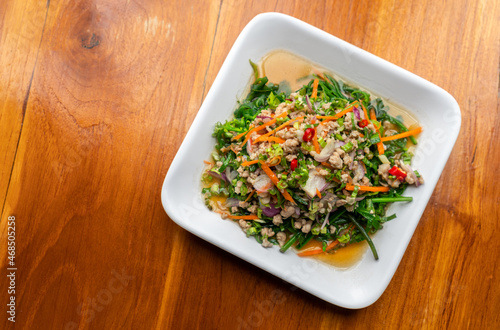Yum Pak Khut or Diplazium Sour and spicy salad with a combination of chili, lime, shallot, carrot, herbs, minced pork, and some sauce. Healthy Thailand food menu. Top view image. photo