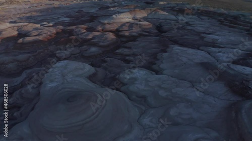 Drone footage of smooth alien like rock mounds and valleys in Mars State Park, Utah, USA during blue hour sunset with Mt Ellen Peak in the far background photo