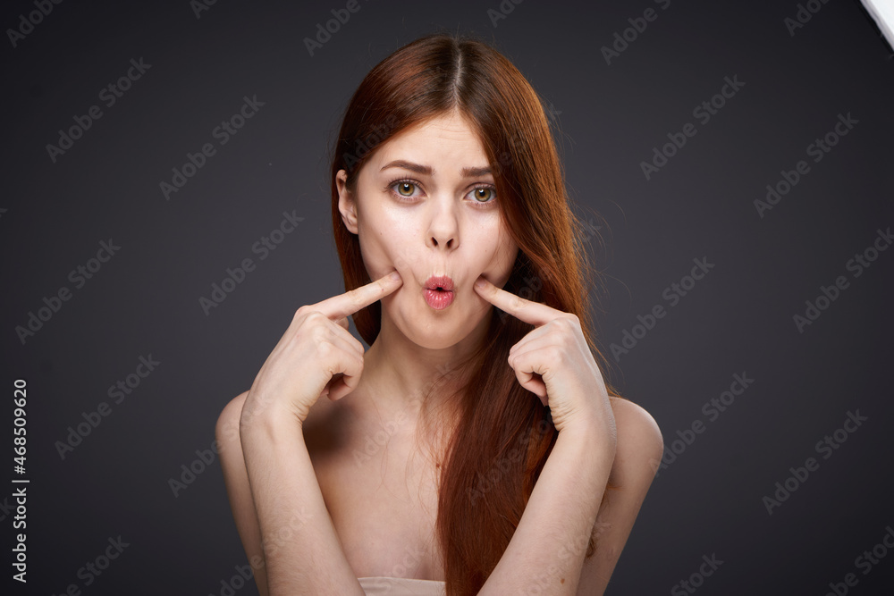 Obraz premium pretty red-haired woman naked shoulders posing dark background