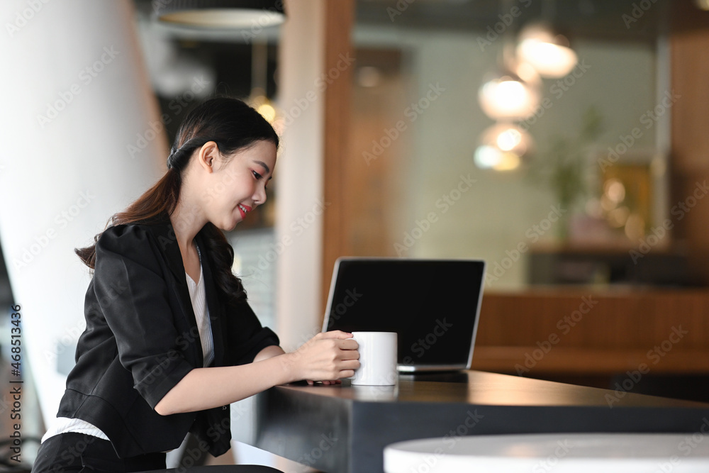 Side view young businesswoman having coffee break at workplace. Side view young businesswoman having coffee break at workplace.