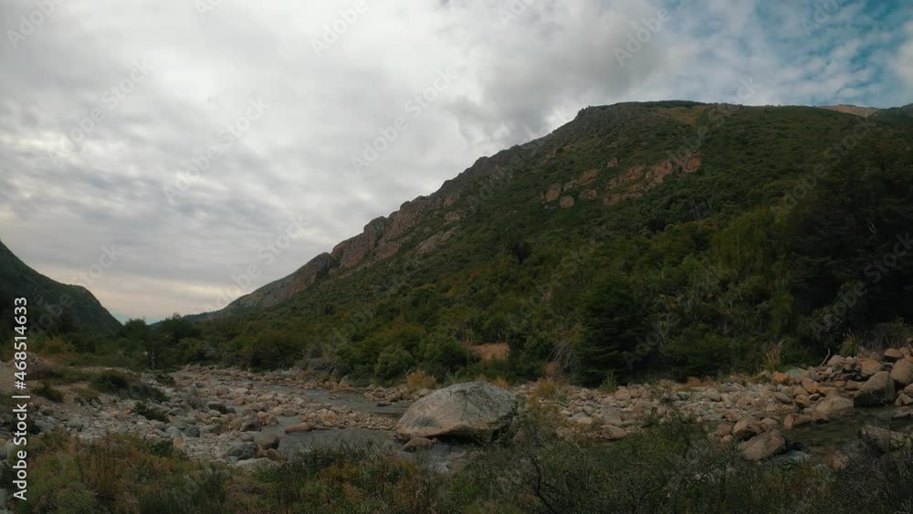 Water flows over the Casa de Piedra stream, under a cloudy sky, on the way to the general San Martin refuge in San Carlos de Bariloche, Argentina. Loop time lapse scene Water flows over the Casa de Piedra stream, under a cloudy sky, on the way to the general San Martin refuge in San Carlos de Bariloche, Argentina. Loop time lapse scene