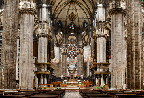 Altar with statues and a huge stained glass window in the Duomo. Italy, Milan © Nadtochiy