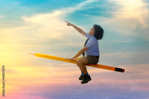 portrait of boy pointing away while flying on pencil