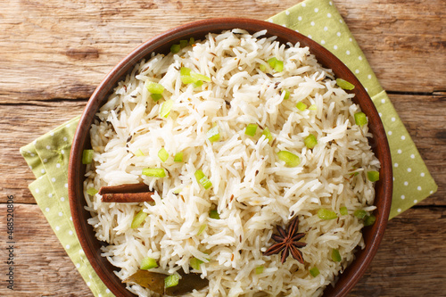 Jeera rice is a popular rice dish having the flavour of cumin and other spices close up in the bowl on the table. Horizontal top view from above