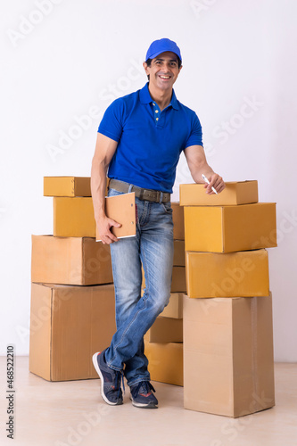 Delivery man standing with cardboard boxes with holding checking list and pen in hands © IndiaPix