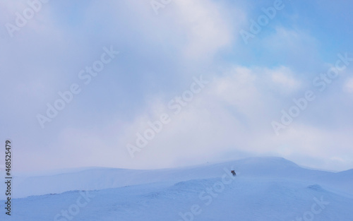 Snow-capped peaks of a mountain range. Winter landscape with snowboarder.