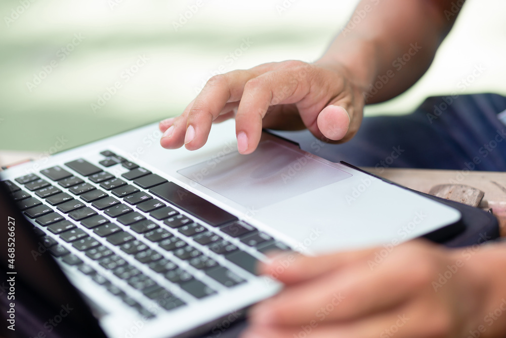 Focus on hand asian man using laptop working outdoor. Concept one person working with new normal Focus on hand asian man using laptop working outdoor. Concept one person working with new normal