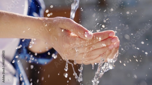a stream of wet transparent clean water is poured onto the hands, observe the hygiene of clean human skin, moisturize and wash fingers, clean and wash after work, wash off the dirt, close-up