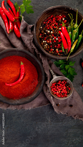 Foto Red chili or chilli cayenne pepper and peppercorns on dark background
