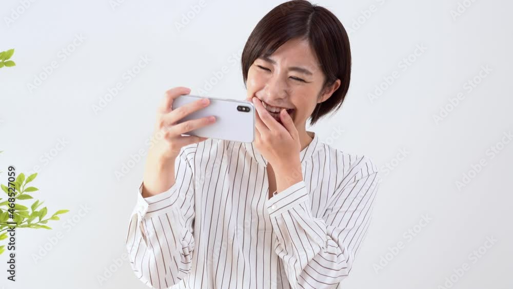 携帯を笑顔で見る日本人女性 携帯を笑顔で見る日本人女性