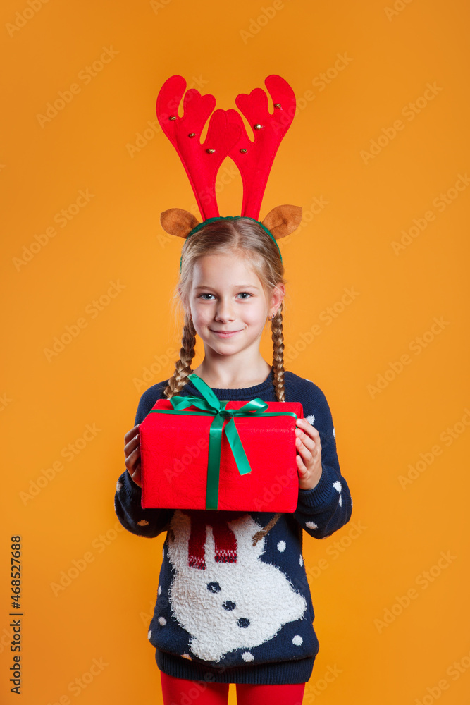 happy funny emotional child girl in red Christmas reindeer costume holding gift happy funny emotional child girl in red Christmas reindeer costume holding gift