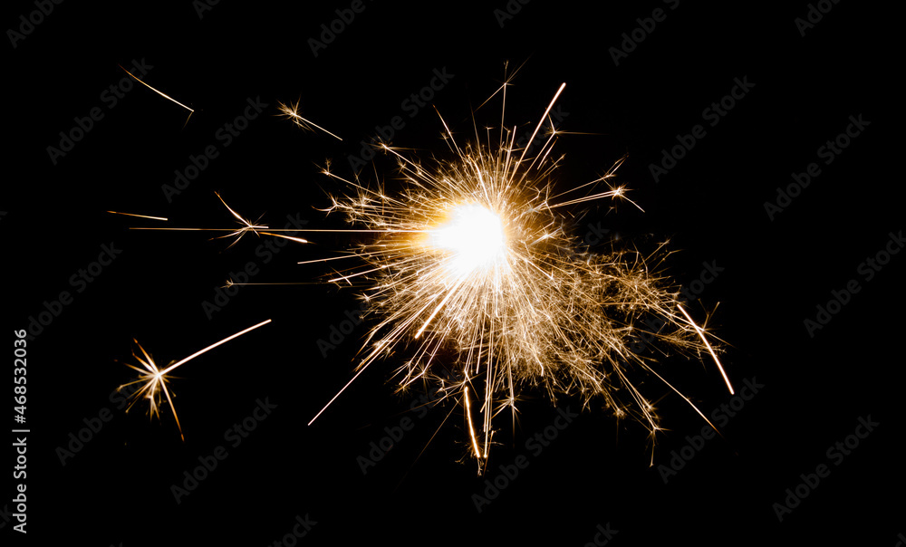 New Year's Eve celebration with a sparkler, isolated on black background.
