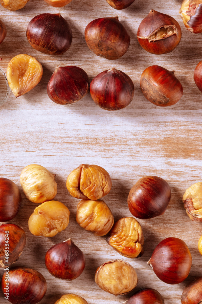 Roasted chestnuts, shot from above on a rustic wooden background with a place for text, autumn banner design Roasted chestnuts, shot from above on a rustic wooden background with a place for text, autumn banner design