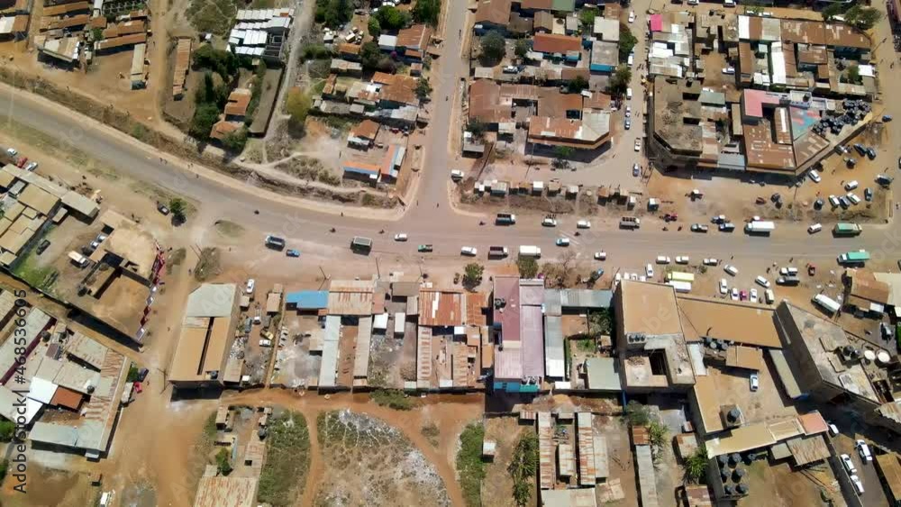 Aerial of traffic driving over road near slum town in rural Kenya Aerial of traffic driving over road near slum town in rural Kenya