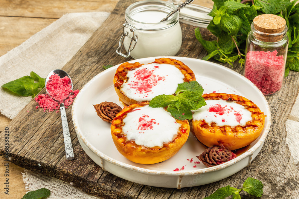 Grilled peach with yogurt, mint, and sweet pink sugar. Useful breakfast concept, healthy food