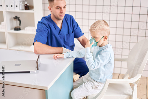 A pediatrician diagnoses lung disease and provides treatment. Breathe the medicine through a nebulizer inhaler.. Portrait of adorable little boy visiting doctor.