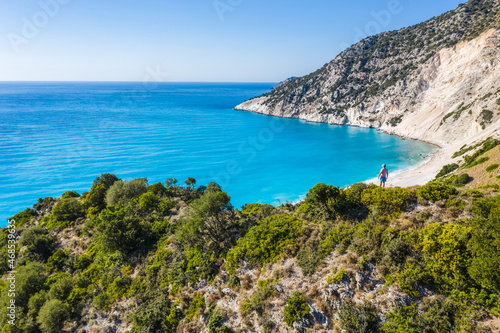 Man tourist standing on top of a rock enjoying Myrtos Beach. Cephalonia island, Greece