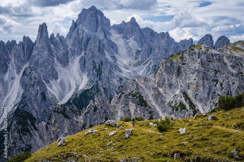 Woman hiker with backpack against Cadini di Misurina mountain group range of Italian Alps  Dolomites  Italy  Europe