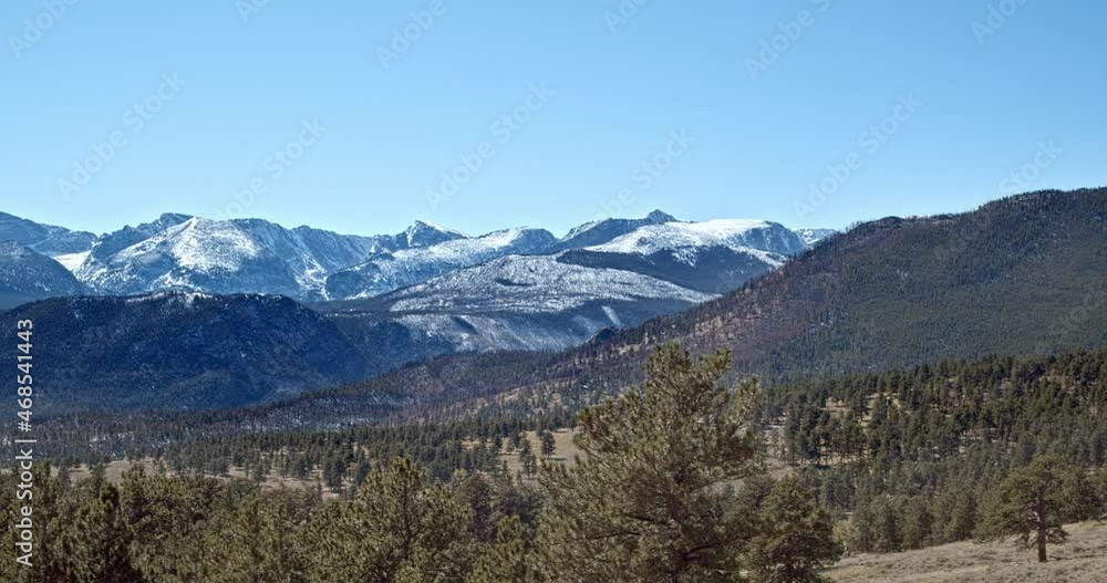 Pan over green valley over to large snow-topped mountains Pan over green valley over to large snow-topped mountains