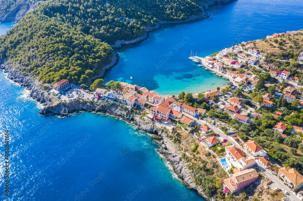 Assos picturesque fishing village from above, Kefalonia, Greece. Aerial drone view. Sailing boats moored in turquoise bay