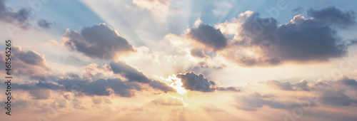 Foto Beautiful fluffy clouds and rays of sunshine painted in dramatic colors at sunse