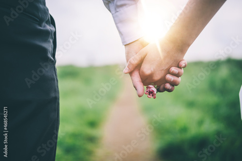 A couple holding hands on the street.