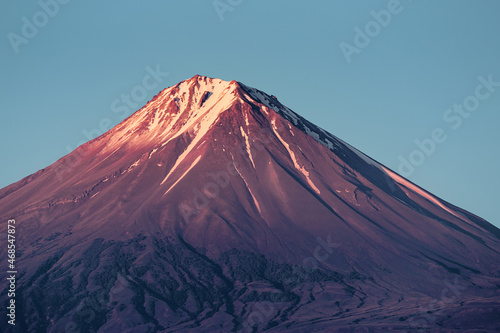 Mount Sis or Lesser Ararat with an ideal conical volcano shape. The peak with the caldera and glaciers is illuminated by the rising sun.