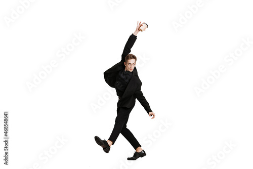Young man in black business suit dancing isolated on white background. Art, motion, action, flexibility, inspiration concept. © master1305