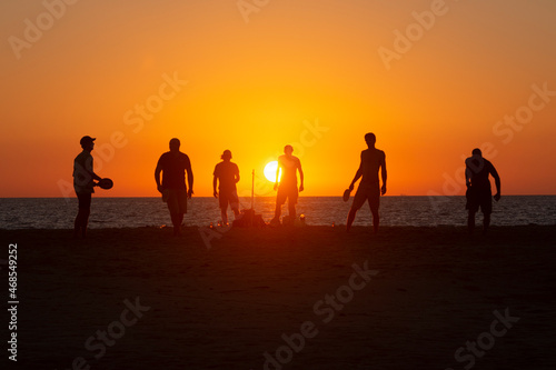 Un grupo de amigos juegan y se divierten al atardecer en la playa de Los Lances, Tarifa, Cádiz, Andalucía, España photo