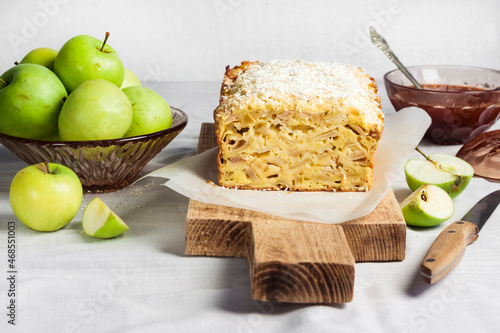 Apple and coconut loaf cake on wooden cutting board photo