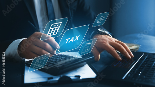 Financial research,government taxes and calculation tax return concept. Businessman using the laptop to fill in the income  tax online return form for payment.  photo