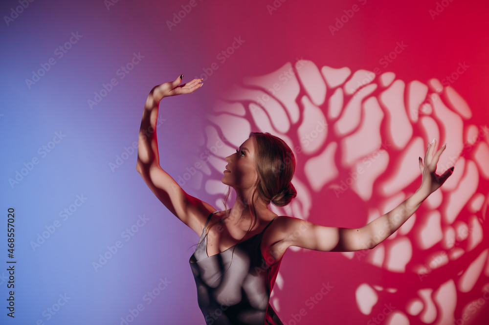 Naklejka premium beautiful girl in a dress, blonde hair, dancing on a colored background with a pattern