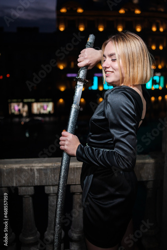 Young woman with sword on night city background
