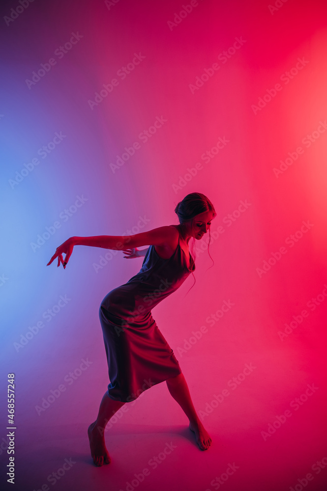 beautiful girl in a dress, blonde hair, dancing on a colored background with a pattern