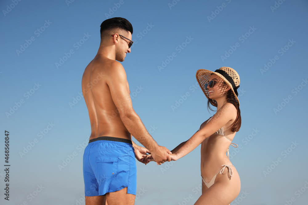 Lovely couple holding hands against blue sky Lovely couple holding hands against blue sky