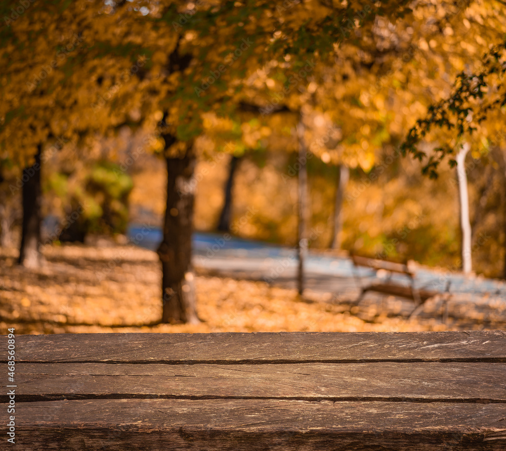Empty old brown wooden table in front of background of autumn orange trees with bokeh for your display or montage
Empty old brown wooden table in front of background of autumn orange trees with bokeh for your display or montage