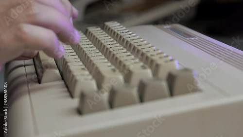 Typing on old computer with monitor lights (close up) photo