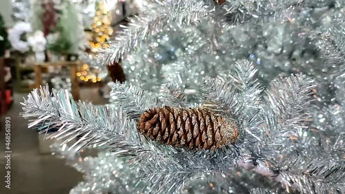 Christmas silver tree decorated with cones and with a bokeh lights background, blur background and fir tree for Christmas and New Year party or decoration idea.