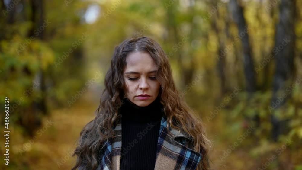 lonely sorrowful woman is walking in park alley in autumn day under falling leaves lonely sorrowful woman is walking in park alley in autumn day under falling leaves