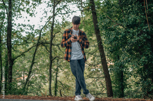 adolescent male with mobile phone in autumn outdoors