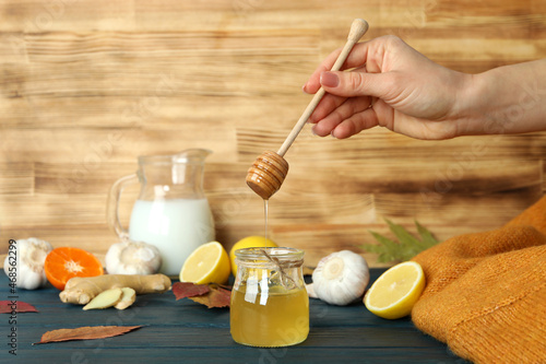 Concept of treatment colds with honey and garlic on wooden table