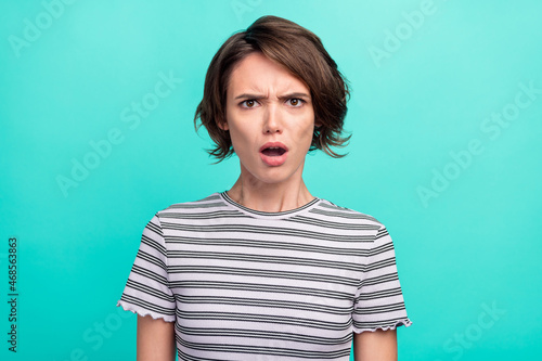 Photo of young girl unhappy sad negative angry amazed fake novelty news isolated over teal color background