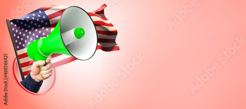 Loudspeaker next to USA flag. Hand holds out loudspeaker. Metaphor for propaganda in United States of America. America's protests and appeals concept. Place for text near USA flag.