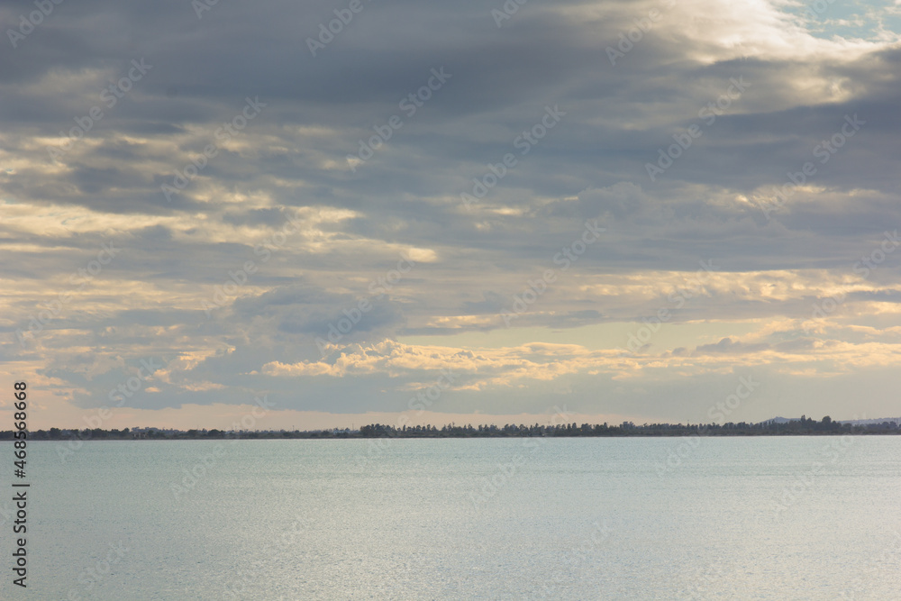 Sea and clouds and a strip of land on the horizon.