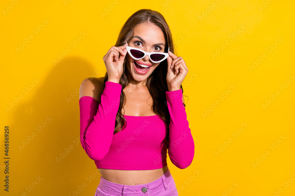 Portrait of attractive glad stunned cheerful wavy-haired girl touching specs wow isolated over vibrant yellow color background Portrait of attractive glad stunned cheerful wavy-haired girl touching specs wow isolated over vibrant yellow color background